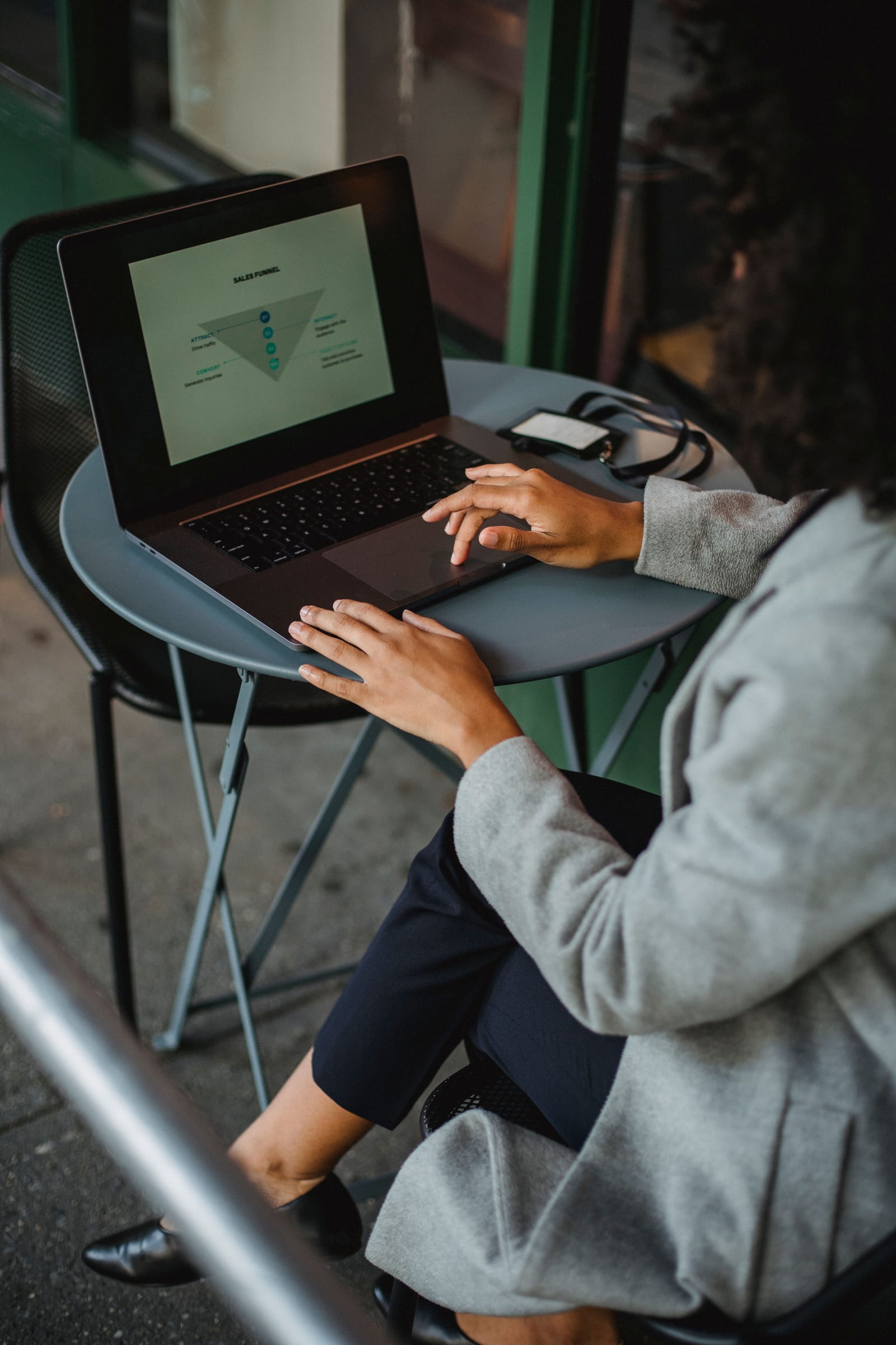 A consultant reviewing a sales funnel slide on her laptop before a client meeting